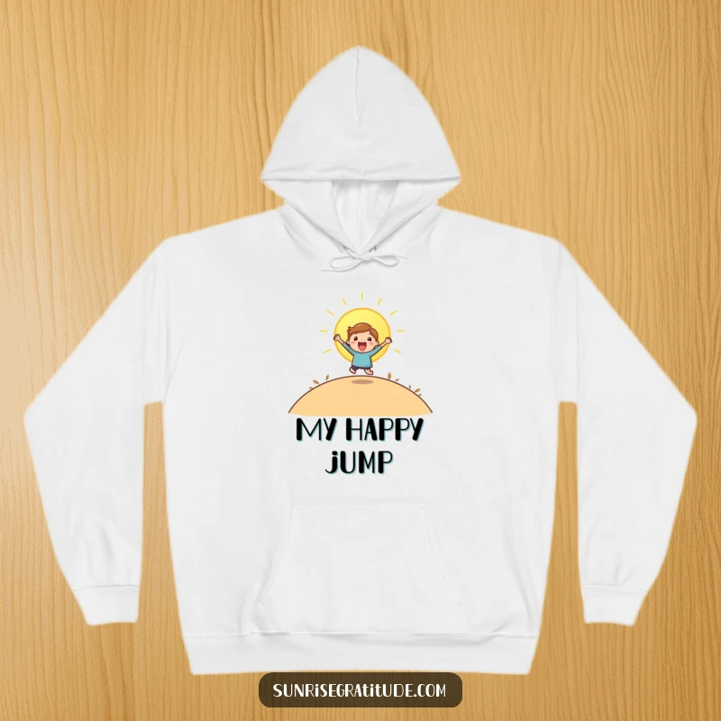 Funny hoodie featuring a playful character joyfully leaping as the sun rises over a scenic hill.